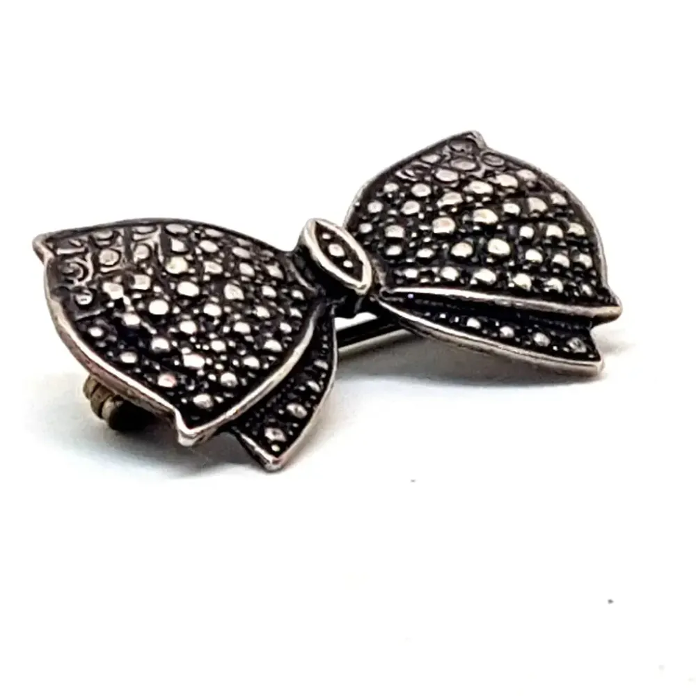 Broche de plata clásico con forma de lazo en plata grabada. Circa 1960. Joyerí. con Mecanismo de Doble Seguro